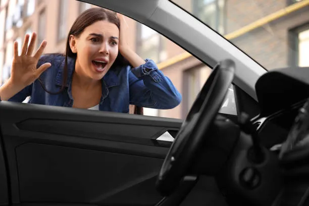 Technician unlocking a car door with keys locked inside during a car lockout call